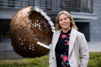 Dr Katriona O’Sullivan, standing in front of an art in form of ball.