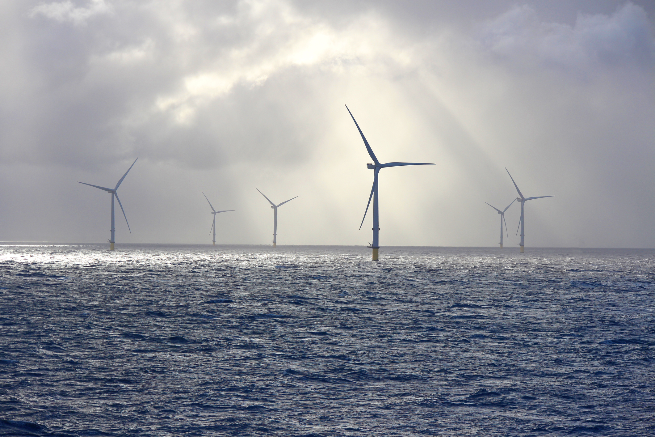 an offshore wind farm and crepuscular rays of sunshine
