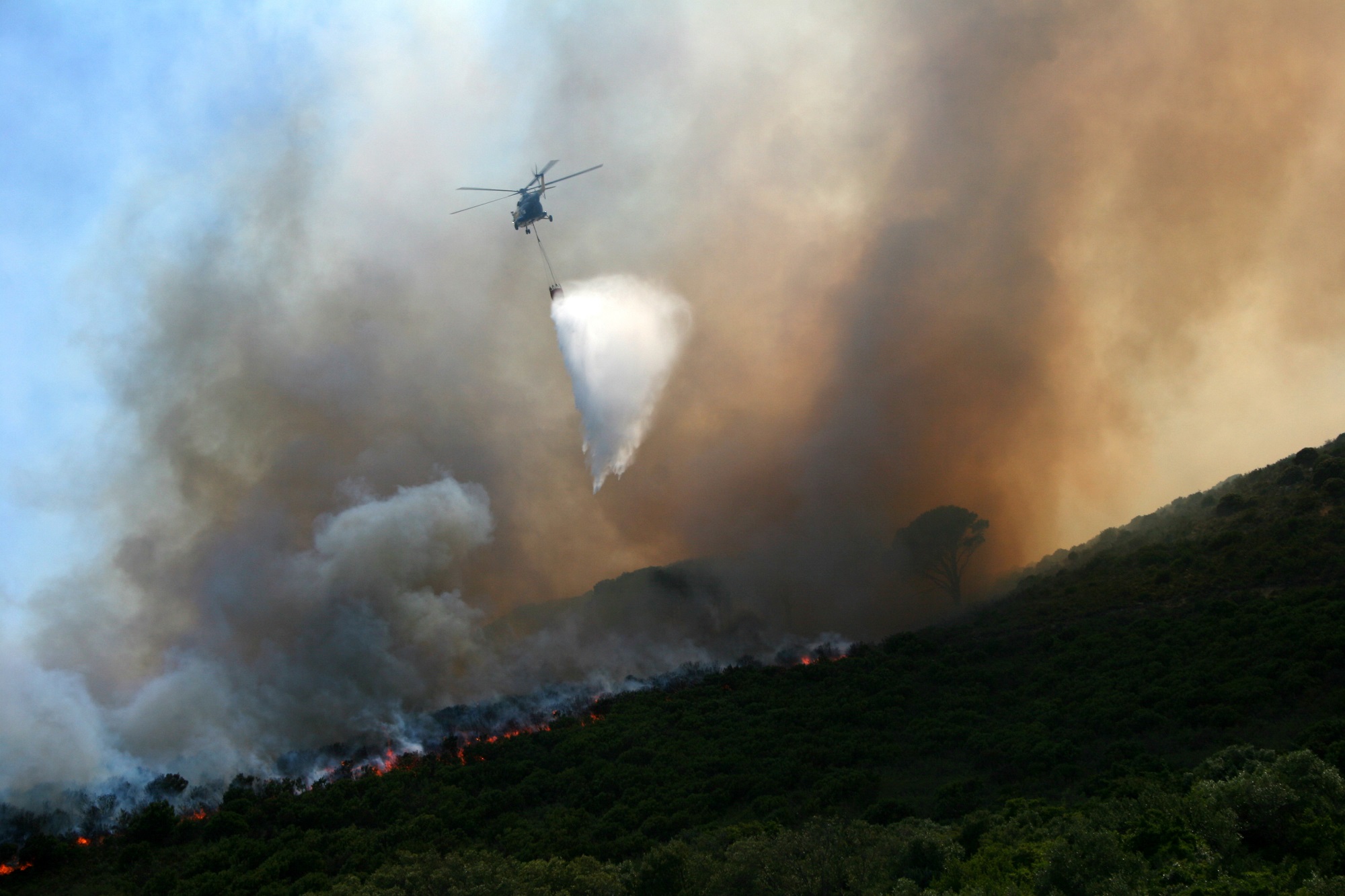 Picture of a helicopter flying over a wild fire