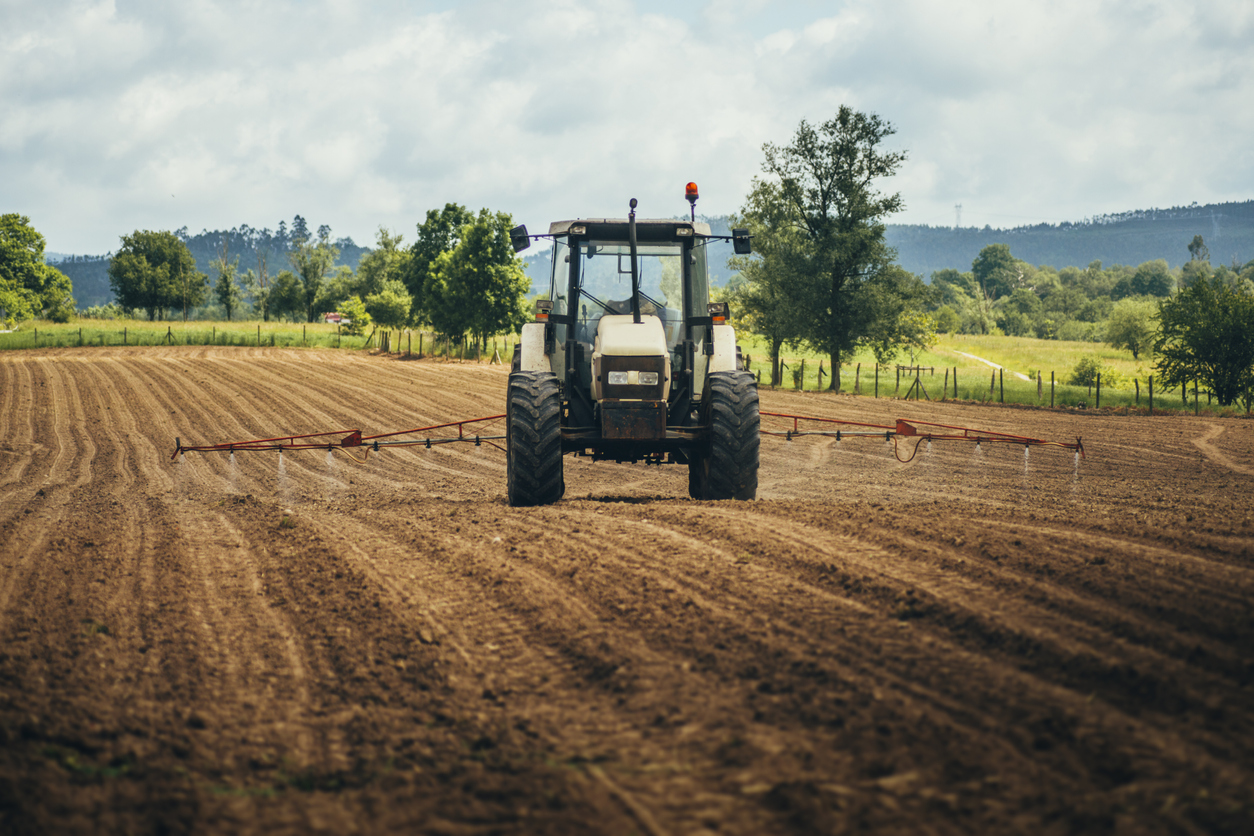 a tractor moving across a ploughed field
