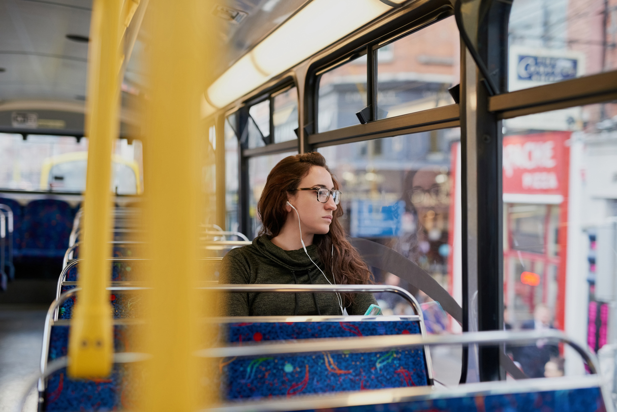 woman sitting on a city bus looking out the window
