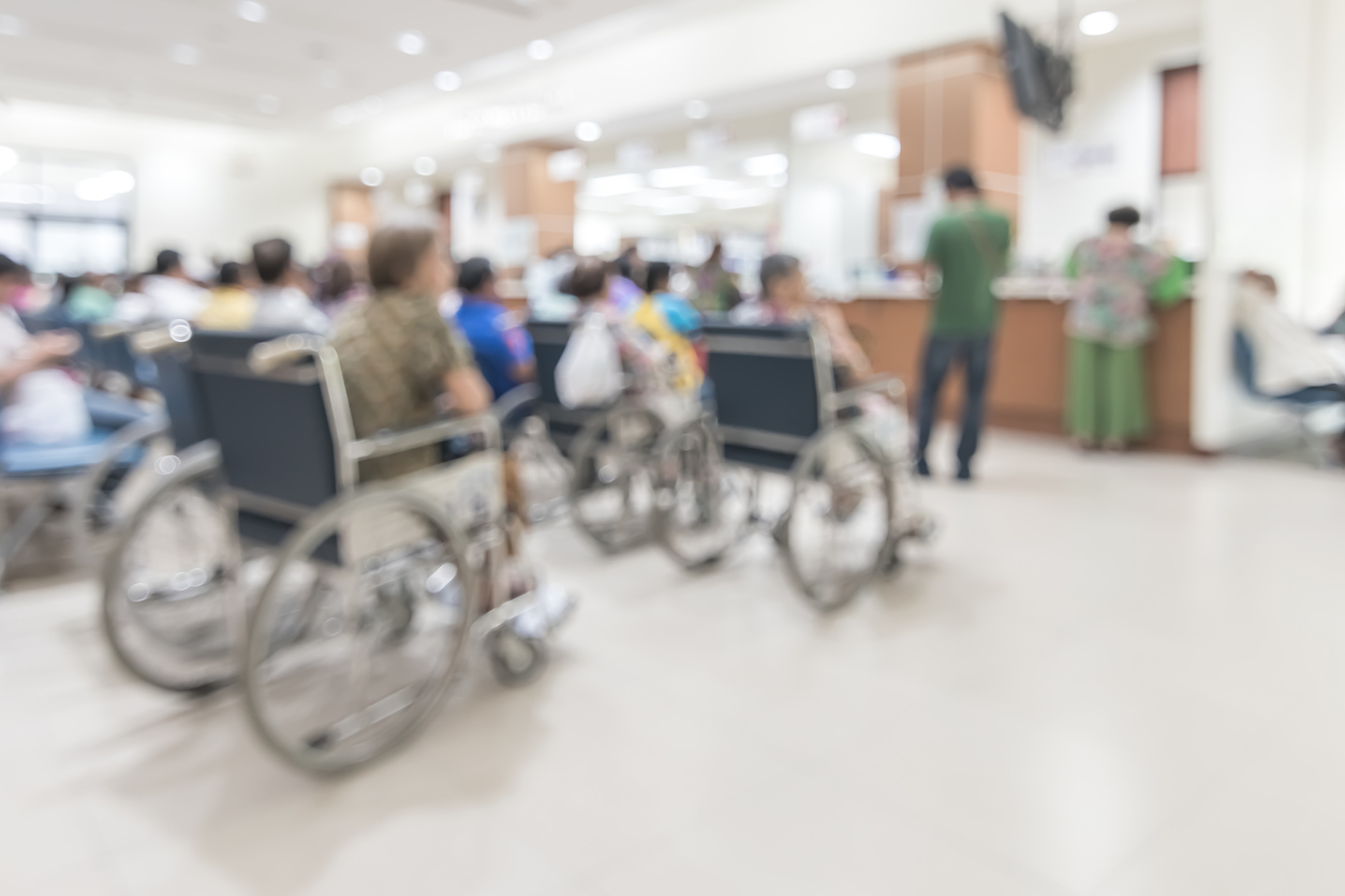 blurred image of people seated waiting in a hospital