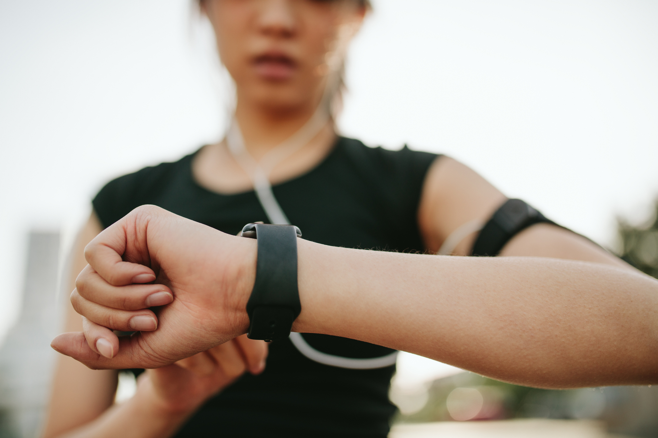 a person out for a run consulting their wearable tech