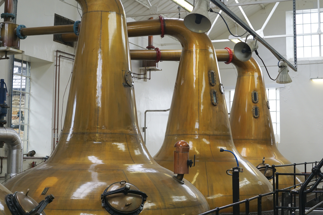 three copper vats in a distillery