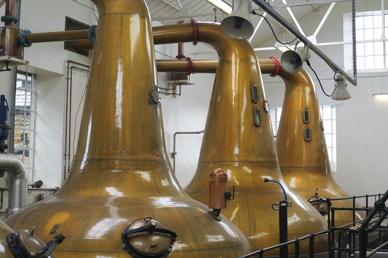 three copper vats in a distillery 
