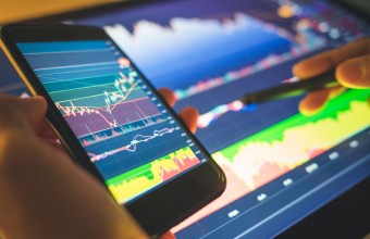 Stock image of phone and tablet with finance graphs