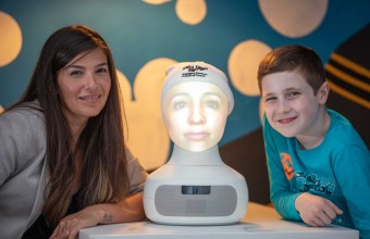 A boy and Girl with a artificial head on a machine between them