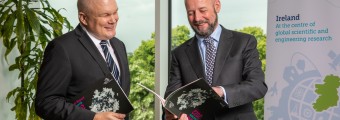 Picture of Prof Peter Clinch and Prof Philip Nolan looking at the SFI Annual Report 2022.