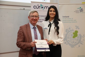 In this image a man is presenting an award to a young female.