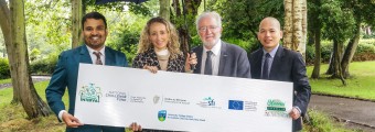 Dr Srikanta Sannigrahi INTERVAL Project team lead, Minister Malcolm Noonan T.D., Minister of State for Nature, Heritage and Electoral Reform, Dr Ruth Freeman, Director of Science for Society, SFI, and Dr Anh Vu Vo, INTERVAL Project team Co -lead standing with project sign under a UCD umbrella. 