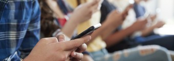A picture of a group of young people on their phones.