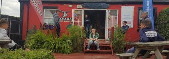 People sitting on benches outside the surf school