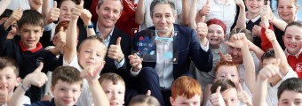 Simon Harris holding curious minds awards among kids