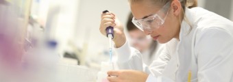 A person using a dropper for testing a liquid