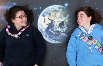 Two young people lying on the floor with a picture of the earth in-between them.