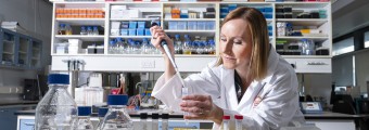 Dr Siobhain O'Mahony wearing a lab coat investigating the role of the gut microbiome in driving differences in pain sensation between men and women.