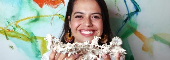 There is a female holding a sample of coral at the opening of iCRAG's ReSToRE Summer School.