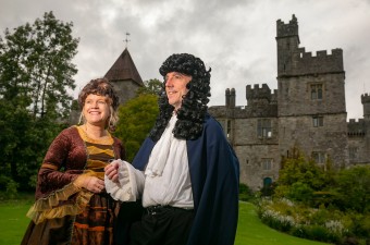 Image of man and woman standing outside a castle on a cloudy day.