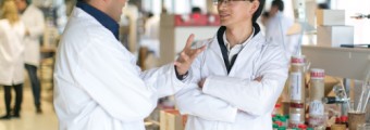 Two people in a lab wearing a lab coat