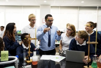 Image of a male teacher doing an science experiment with his group of students