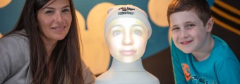 A boy and Girl with a artificial head on a machine between them