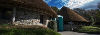 Huts made of stone and thatch roof holding the front entrance to Lough Gur