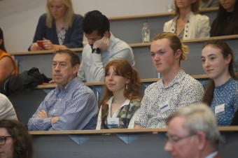 Many people sitting in a lecture room paying close attention