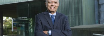 Professor Subrata Ghosh standing outside UCC smiling with his arms crossed.