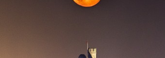 A bright orange moon sits above the CIT Blackrock Castle Observatory 