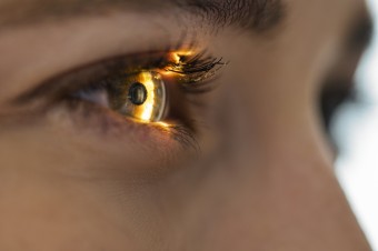 Close up image of a persons eye with a bright light shining on it 