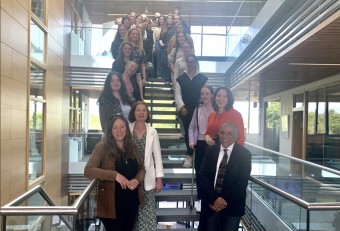 In this image there are many people standing on a staircase