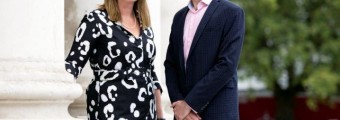 Image of Prof Matthew Campbell and Prof Sarah Doyle from Trinity College Dublin neatly dressed standing outside a white pillar with green scenery in the background.