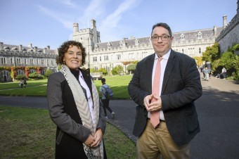 A man and woman standing outside UCC university dressed professionally