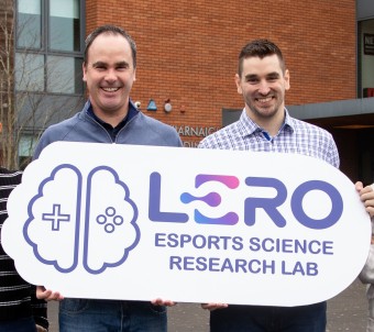 Professor Mark Campbell and Dr Adam Toth holding a sign written Lero and an image of a brain