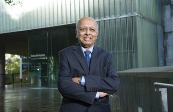 Professor Subrata Ghosh standing outside UCC smiling with his arms crossed.