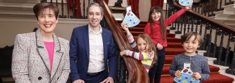 Minister Harris and Norma Foley pictured with three young children on a staircase