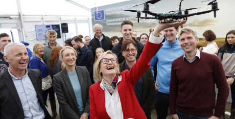 Commissioner McGuinness holds drone above fellow speakers at National Ploughing Championships